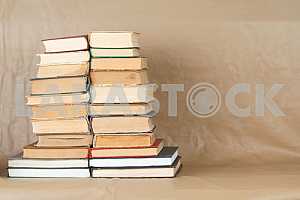 Old and used hardback books or text books on wooden table. Books and reading are essential for self improvement, gaining knowledge and success in our careers, business and personal lives. Copy space