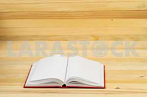 Открытая книга, стопка книг в твердом переплете на деревянном столе. Обратно в школу. Копирование пространства