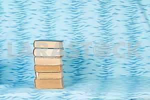 Old and used hardback books or text books on wooden table. Books and reading are essential for self improvement, gaining knowledge and success in our careers, business and personal lives. Copy space