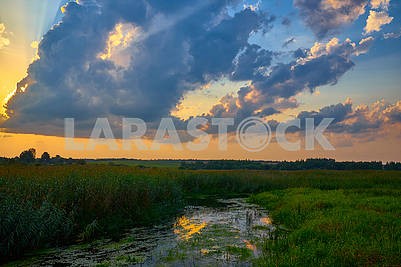 Beautiful sunset on river under cloudy sky