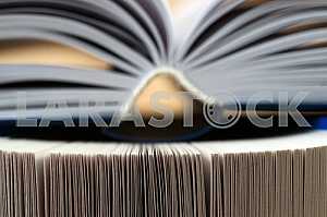 Open book, stack of hardback books. Back to school.