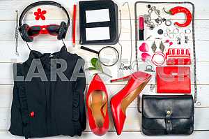 Women clothing set and accessories on white wooden background.