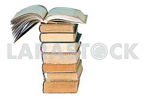Old and used hardback books or text books on wooden table. Books and reading are essential for self improvement, gaining knowledge and success in our careers, business and personal lives. Copy space