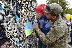 Military and child visiting a camouflage net