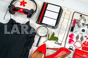 Women clothing set and accessories on white wooden background.