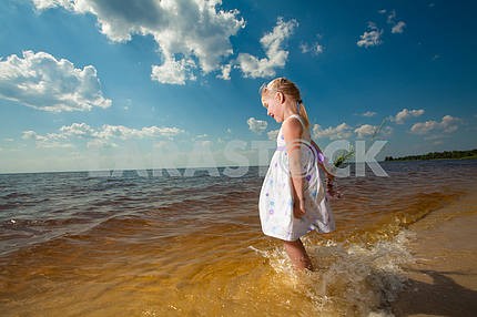 Cute girls play in the waves on sea