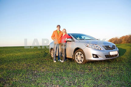 Счастливая молодая пара с нового автомобиля