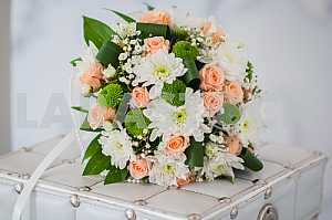 Wedding bouquet made of roses, chrysanthemum and laying on the white box
