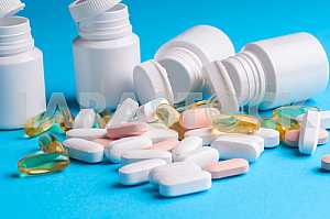 Many pills and tablets isolated on light blue background