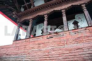 A man sleeps on the railing of the porch of the old church