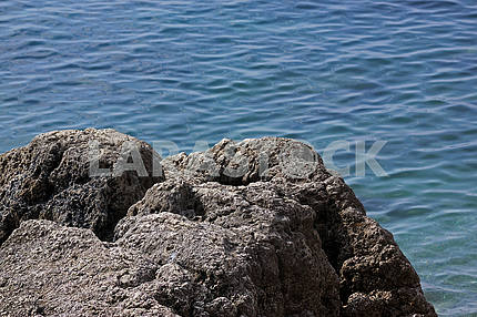 Rock on a background of blue water