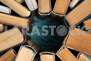 Old and used hardback books or text books on wooden table. Books and reading are essential for self improvement, gaining knowledge and success in our careers, business and personal lives. Copy space