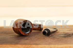 Smoking pipe on a wooden table. Aroma. Copy space