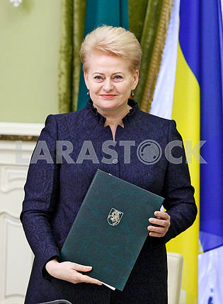 Dalia Grybauskaite smiles with documents in hands