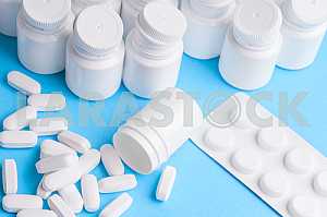 Many pills and tablets isolated on light blue background