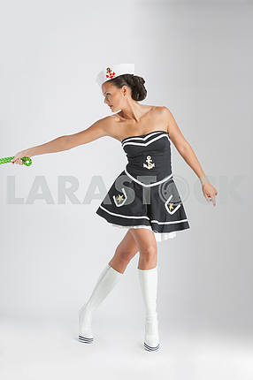 Beauty pinup girl in a sailor suit rope pulling