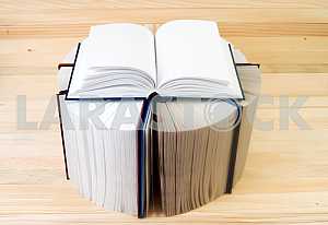 Open book, stack of hardback books on wooden table. Back to school. Copy space