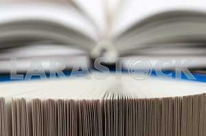 Открытая книга, стопка книг в твердом переплете на деревянном столе. Обратно в школу. Копирование пространства