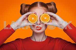 Young beautiful fashion model with orange. studio shot.