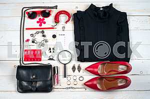 Women clothing set and accessories on white wooden background.
