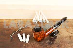 Smoking pipe on a wooden table. Aroma. Copy space