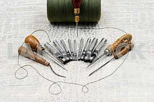 Leather craft tools on a leather background. Craftsman work desk . Piece of hide and working handmade tools on a work table. Top view. Copy space