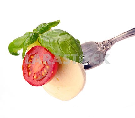 Mozzarella with tomato and basil on fork