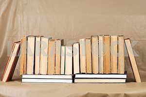 Old and used hardback books or text books on wooden table. Books and reading are essential for self improvement, gaining knowledge and success in our careers, business and personal lives. Copy space