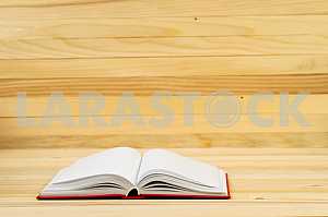 Открытая книга, стопка книг в твердом переплете на деревянном столе. Обратно в школу. Копирование пространства