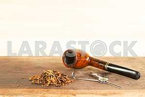 Smoking pipe on a wooden table. Aroma. Copy space