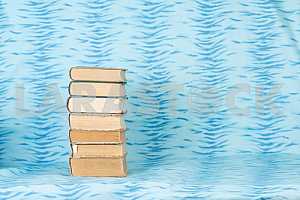 Old and used hardback books or text books on wooden table. Books and reading are essential for self improvement, gaining knowledge and success in our careers, business and personal lives. Copy space