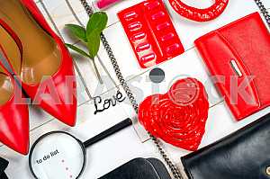 Women clothing set and accessories on white wooden background.