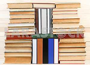 Открытая книга, стопка книг в твердом переплете на деревянном столе. Обратно в школу. Копирование пространства