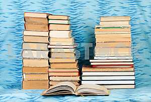 Old and used hardback books or text books on wooden table. Books and reading are essential for self improvement, gaining knowledge and success in our careers, business and personal lives. Copy space