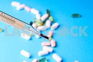 Many pills and tablets isolated on light blue background