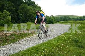 Tourists with backpacks on the bike in the Carpathian Mountains