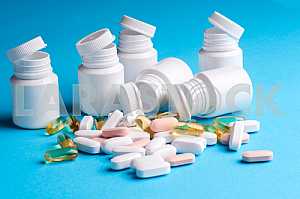 Many pills and tablets isolated on light blue background