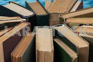 Old and used hardback books or text books on wooden table. Books and reading are essential for self improvement, gaining knowledge and success in our careers, business and personal lives. Copy space