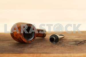 Smoking pipe on a wooden table. Aroma. Copy space