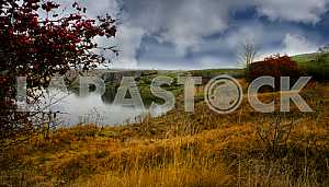 Red hawthorn, lakeside Monastyryshche autumn against the blue sky. tract cascades