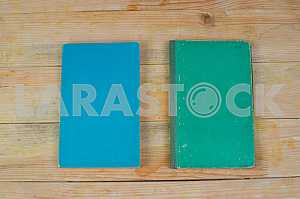 Open book, stack of hardback books on wooden table. Back to school. Copy space