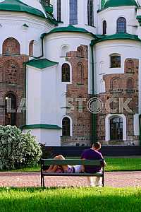 The guy and the girl have a rest from the ancient walls of St. Sophia Cathedral in Kiev in 2012