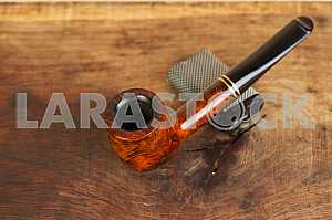 Smoking pipe on a wooden table. Aroma. Copy space
