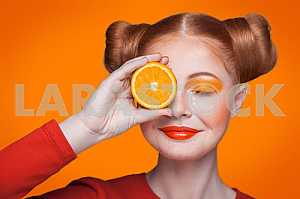 Young beautiful fashion model with orange. studio shot.