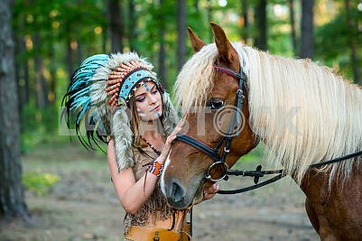 Красивая девушка в костюме индейской женщины в плотва с лошадью
