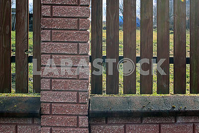 Fence of wooden rails and bricks