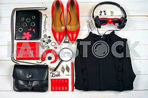 Women clothing set and accessories on white wooden background.
