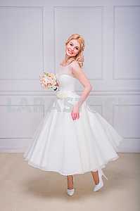 Blonde beautiful bride in short dress with wedding bouquet