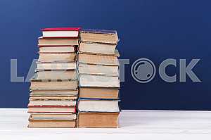 Stack of hardback books on wooden table. Back to school. Copy space