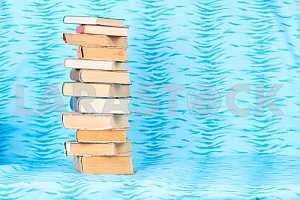 Old and used hardback books or text books on wooden table. Books and reading are essential for self improvement, gaining knowledge and success in our careers, business and personal lives. Copy space